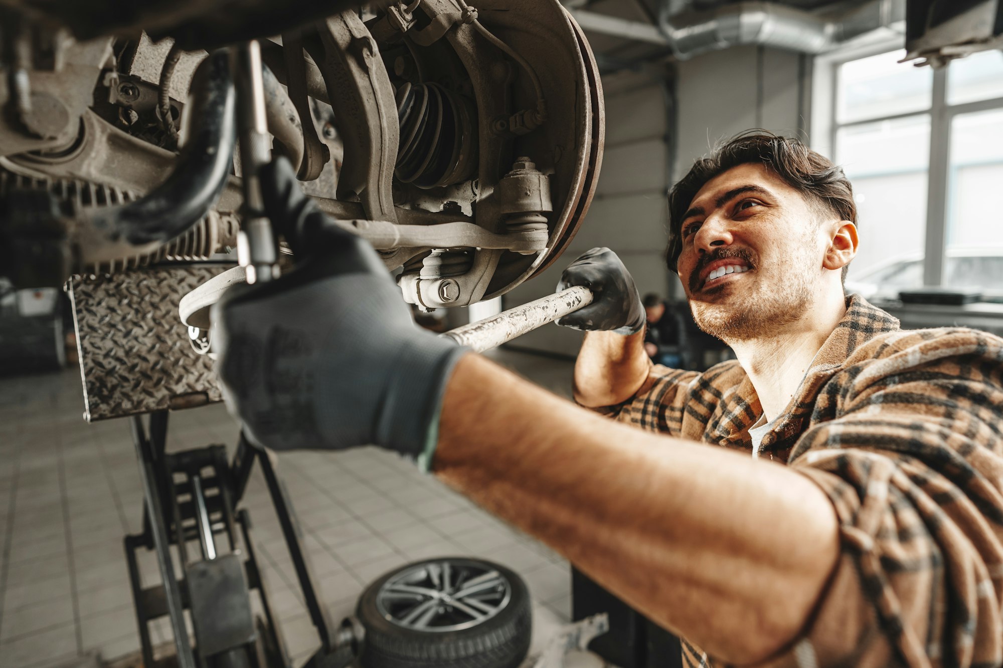 Auto mechanic repairs running gear of a car in car service